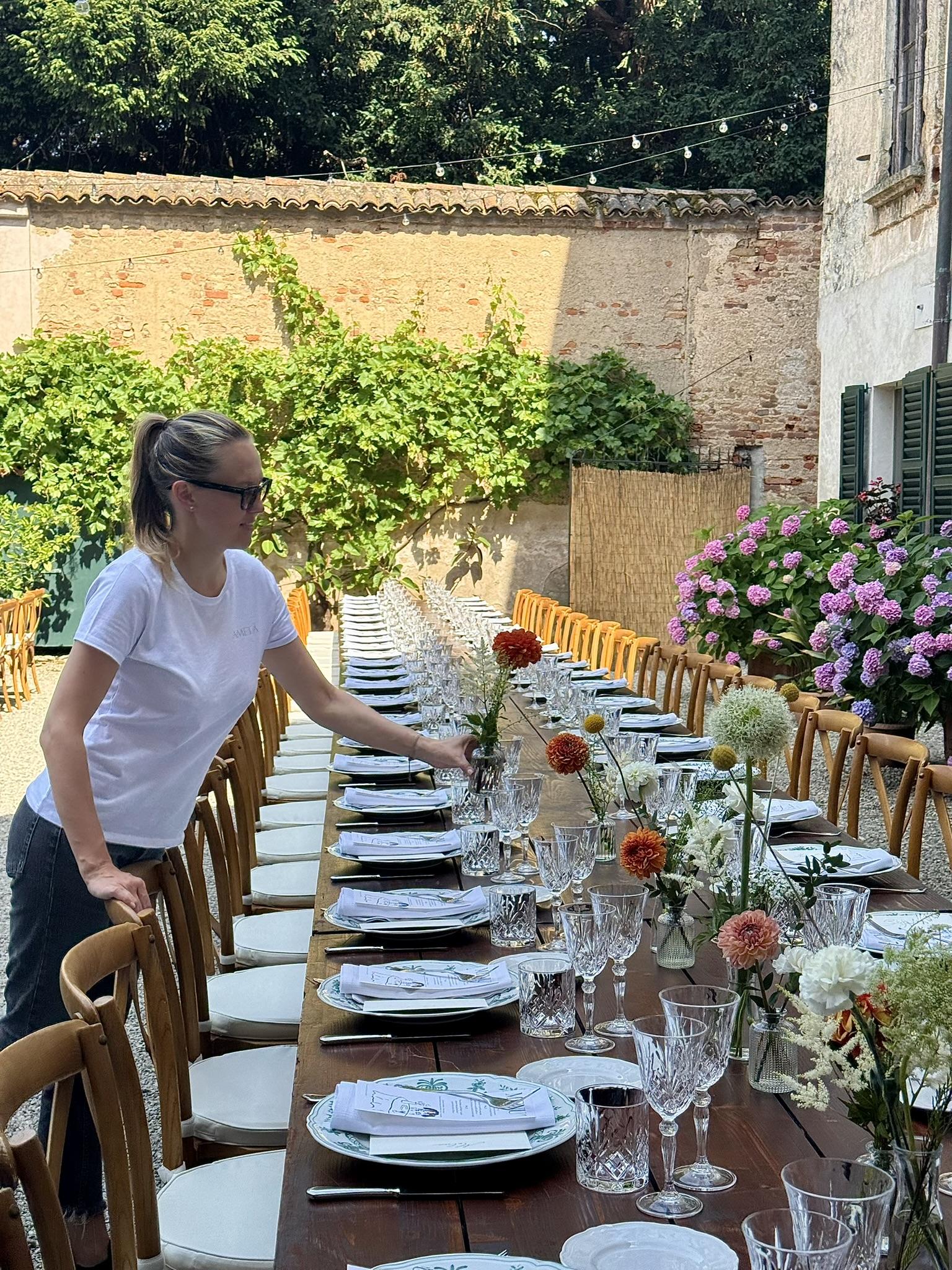 Aleksandra al lavoro, mentre allestisce una lunga tavolata per un matrimonio